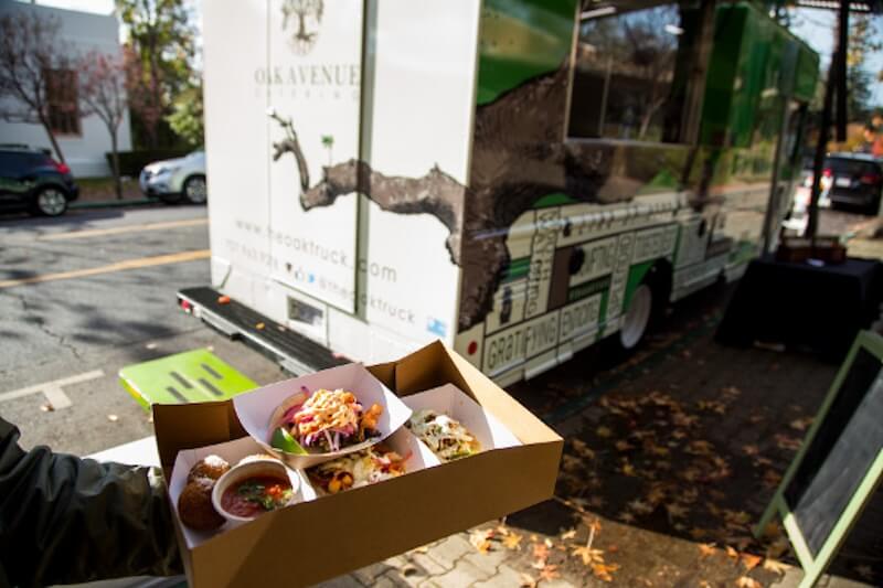 person holding to-go food in front of Out On a Limb Food Truck